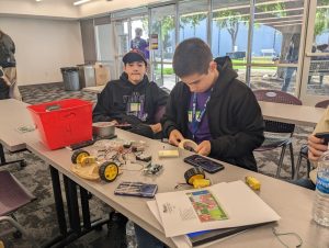 Two students building a robot